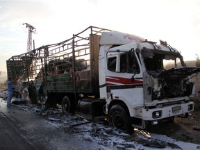 A damaged truck carrying aid is seen on the side of the road in the town of Orum al-Kubra on the western outskirts of the northern Syrian city of Aleppo on September 20, 2016, the morning after a convoy delivering aid was hit by a deadly air strike. The UN said at least 18 trucks in the 31-vehicle convoy were destroyed en route to deliver humanitarian assistance to the hard-to-reach town.  /