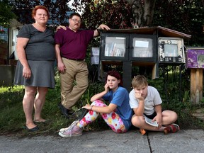 Mimi and Tim Golding pose beside there little library with daughter Isabelle and son Henry.