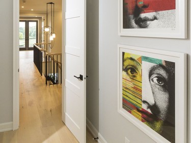 Upstairs hallway: The hardwood continues throughout the second floor, where the hallway is highlighted by another Hubbardton Forge light fixture, the Treble Pendant, which continues the geometric theme of the home. A feature wall of painted wood planks (supplied by Alexandria Moulding) provides a subtle backdrop in the stairwell that also adds texture.