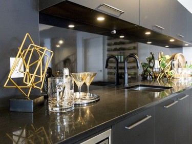 Wet bar: An unusual choice for kitchen cabinetry, the pantry is a matte black with a chalkboard-like finish with gunstock metal hardware. It serves to visually separate the formal and informal living areas without being obtrusive, while also anchoring the space.