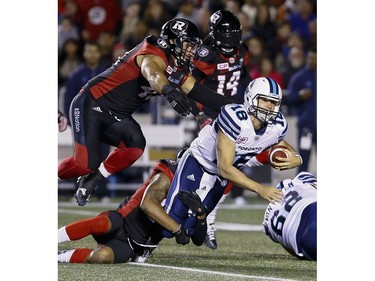Toronto Argonauts quarterback Dan LeFevour (18) is tackled by Ottawa Redblacks linebacker Damaso Munoz.