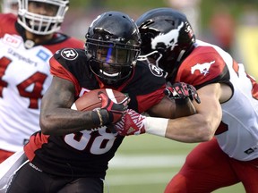 Ottawa Redblacks' Tristan Jackson (38) runs the ball against the Calgary Stampeders during the first half of a CFL football game in Ottawa on July 8, 2016.