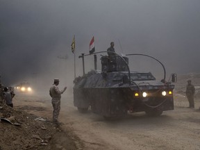 An Iraqi Federal Police vehicle passes through a checkpoint in Qayara, some 50 kilometers south of Mosul, Iraq, Wednesday, Oct. 26, 2016. Islamic State militants have been going door to door in farming communities south of Mosul, ordering people at gunpoint to follow them north into the city and apparently using them as human shields as they retreat from Iraqi forces. Witnesses to the forced evacuation describe scenes of chaos as hundreds of people were driven north across the Ninevah plains and into the heavily-fortified city, where the extremists are believed to be preparing for a climactic showdown. (AP Photo/Marko Drobnjakovic) ORG XMIT: XMD101