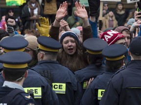 A protester holds up her hands as police bar oil pipeline protesters from using a gate to enter Parliament Hill Monday October 24, 2016 in Ottawa. The protesters were allowed to use another entrance unobstructed.