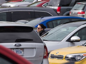 A woman in a sea of vehicles in the parking lot located behind the Civic Hospital. There are early signs that parking will be the next battle on the road to a new $2 billion super hospital in Ottawa.