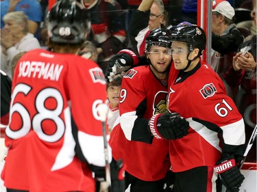 Bobby Ryan, centre, looks at Mike Hoffman, left, while hugging Mark Stone, right.