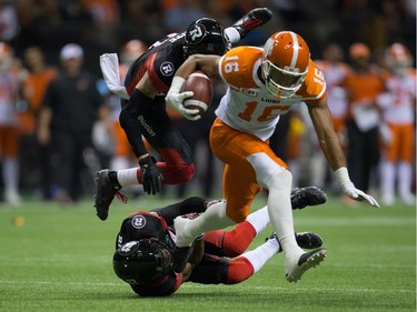 B.C. Lions' Bryan Burnham, front, gets away from Ottawa Redblacks' Mitchell White and Jeff Richards, bottom, during the first half of a CFL football game in Vancouver, B.C., on Saturday October 1, 2016.