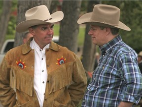 Files:  Federal Indian Affairs Jim Prentice talks to Prime Minister Stephen Harper in Calgary in July. 2007.