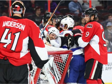 Craig Anderson of the Ottawa Senators looks on as a skirmish breaks out beside his net.