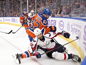Washington Capitals' Daniel Winnik (26) is checked by Edmonton Oilers' Eric Gryba (62) during first period NHL action in Edmonton, Alta., on Wednesday October 26, 2016.