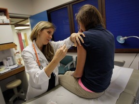 University of Miami pediatrician Judith L. Schaechter, M.D. (L) gives an HPV vaccination to a 13-year-old girl in her office at the Miller School of Medicine on September 21, 2011 in Miami, Florida. The vaccine for human papillomavirus, or HPV, is given to prevent a sexually transmitted infection that can cause cancer.