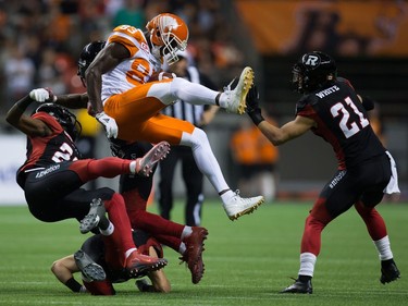 B.C. Lions' Stephen Adekolu, centre, collides with Ottawa Redblacks' Forrest Hightower, left, Antoine Pruneau, bottom, and Jerrell Gavins, back, after making a reception as Mitchell White, right, watches during the second half of a CFL football game in Vancouver, B.C., on Saturday October 1, 2016.