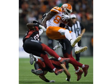 B.C. Lions' Stephen Adekolu, centre, collides with Ottawa Redblacks' Forrest Hightower, left, Antoine Pruneau, bottom, and Jerrell Gavins, back, after making a reception during the second half of a CFL football game in Vancouver, B.C., on Saturday October 1, 2016.
