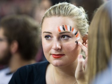 Gabrielle Nichols gets painted up in Carleton University colours.