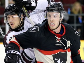 Gee Gee forward Justin Charboneau, left, is held up by Ravens defenceman David Weckworth in the second period.