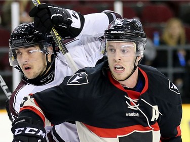 Gee Gee forward Justin Charboneau (L) is held up by Ravens defenceman David Weckworth in the second period as the Carleton Ravens take on the Ottawa Gee-Gees in The Colonel By Classic hockey game.     photo by Wayne Cuddington/ Postmedia ORG XMIT: POS1610191941114579