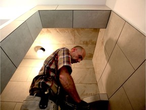 Great tradespeople are careful tradespeople. Here Dale Wallace, an master tile setter in Ontario, applies grout to a tile shower he just built.