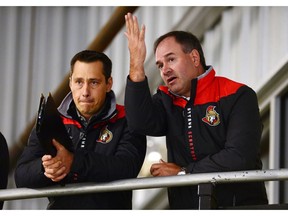 Ottawa Senators head coach Guy Boucher, left, and general manager Pierre Dorion watch their team during day two of training camp in Ottawa on Friday, Sept. 23, 2016.