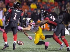 Henry Burris has the ball knocked out of his hand by John Chick, with Mossis Madu trying to go for the loose ball. Hamilton recovered the ball during overtime on Friday, Oct. 21, 2016 at TD Place stadium.