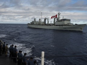 The ship’s company of Her Majesty's Canadian Ship (HMCS) REGINA waves goodbye to HMCS PROTECTEUR during a sail pass on January 19, 2014 in the Pacific Ocean, west of Hawaii en route to Operation ARTEMIS. Photo: Cpl Michael Bastien, MARPAC Imaging