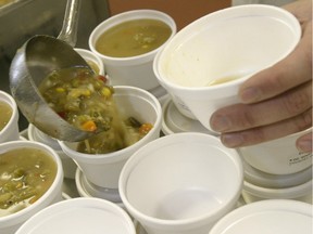 A Meals On Wheels volunteer fills soup containers.