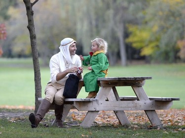 Prime Minister Justin Trudeau, dressed as the Pilot from The Little Prince, left, and his son Hadrien, dressed as the Little Prince, have a treat after trick-or-treating at Rideau Hall, on Halloween, Monday, Oct. 31, 2016 in Ottawa.