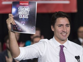 Justin Trudeau holds up a copy of his party's election platform on the campaign trial in October 2015.