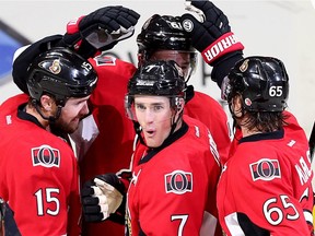 Kyle Turris is congratulated on his goal by Zack Smith (L), Erik Karlsson (R) and Mark Stone (hidden) in the third period.