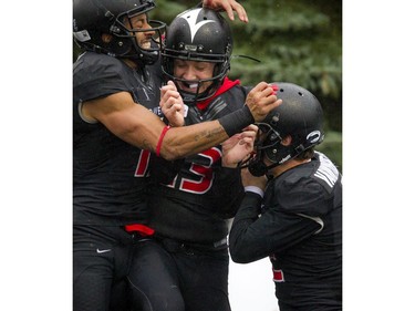 From left, the Carleton Ravens' Phil Iloki, Wilson Birch and Kyle VanWynsberghe celebrate in the end zone during the game against Ottawa University Gee-Gees at MNP Park on Saturday, Oct. 29, 2016.