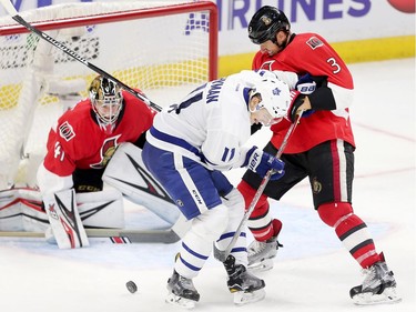 Marc Methot (R) battles with Zach Hyman while goalie Craig Anderson keeps his eye on the puck in the second period as the Ottawa Senators get set to take on the Toronto Maple Leafs in NHL action at the Canadian Tire Centre. Wayne Cuddington/ Postmedia