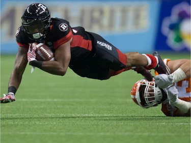 Ottawa Redblacks' Mossis Madu Jr., left, is stopped by B.C. Lions' Craig Roh during the second half of a CFL football game in Vancouver, B.C., on Saturday October 1, 2016.