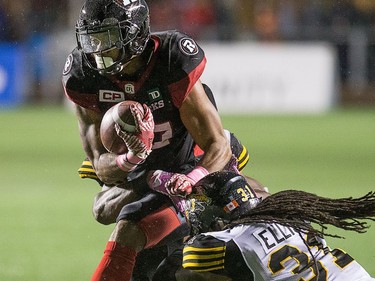 Mossis Madu Jr., left, of the Redblacks is tackled by Dominique Ellis and Simoni Lawrence (behind) of Hamilton during the first half.