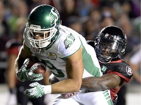 The Saskatchewan Roughriders' Nic Demski is tackled by the Ottawa Redblacks' Jerrell Gavins during first-half CFL action on Friday, Oct. 7, 2016 in Ottawa.