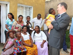 Rosalie Uzamukunda, in the yellow skirt, gathers with Allan Thompson (far right), friends and family outside her house in Gikondo in 2014, before it was badly damaged by flooding and rains in 2016. (Photo provided by Allan Thompson)