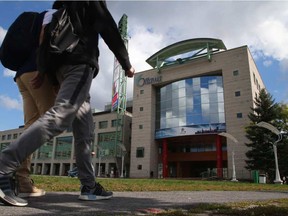 Pedestrians walk past Ottawa city hall.