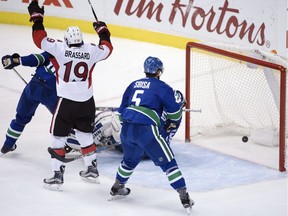 Ottawa Senators centre Derick Brassard (19) celebrates teammate Ryan Dzingel's goal as Vancouver Canucks defenceman Luca Sbisa (5) looks on during third period NHL action in Vancouver, B.C. Tuesday, Oct. 25, 2016.