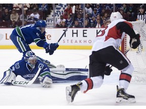 Ottawa Senators left wing Ryan Dzingel (18) scores on Vancouver Canucks goalie Ryan Miller (30) as Vancouver Canucks defenceman Troy Stecher (51) looks on during first period NHL action in Vancouver, B.C. Tuesday, Oct. 25, 2016.