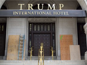 Plywood covers up graffiti at the entrance to the Trump International Hotel, Sunday, Oct. 2, 2016, in Washington. District of Columbia police said someone spray-painted the phrases "black lives matter" and "no justice no peace" on the front of the building on Saturday afternoon.