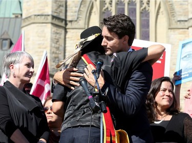 PM Justin Trudeau gets a hug from native leader, Mista Wasis, on the steps of Parliament Hill alongside his Minister of Justice and Attorney General, Jody Wilson-Raybould (right) and  Prime Minister Justin Trudeau, along with a number of his female cabinet ministers, made a surprise visit to a vigil for missing and murdered Indigenous women, girls and Two-Spirit people (MMIWG2S) Tuesday (Oct. 4, 2016) on Parliament Hill.