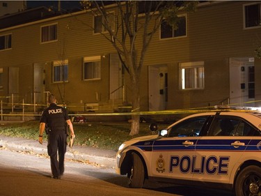 Police survey the scene of an apparent homicide outside of 1411 Rosenthal Ave off of Merivale Rd in the Carlington neighbourhood.   Wayne Cuddington/ Postmedia