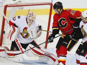 The Calgary Flames' Alex Chiasson looks to tip the puck by Chris Driedger of the Ottawa Senators during action in Calgary on Friday, Oct. 28, 2016.