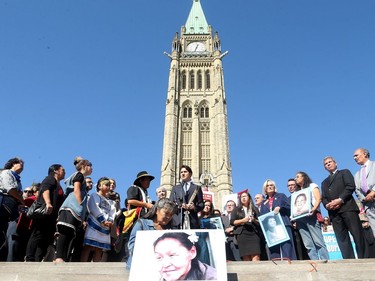 Prime Minister Justin Trudeau, along with a number of his female cabinet ministers, made a surprise visit to a vigil for missing and murdered Indigenous women, girls and Two-Spirit people (MMIWG2S) Tuesday (Oct. 4, 2016) on Parliament Hill.  Kilatja Simeonie (foreground) clutches a portrait of her cousin, native artist, Annie Pootoogook, who recently turned up dead in the Rideau River, as PM Trudeau addresses the crowd.
