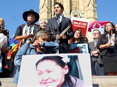 Prime Minister Justin Trudeau, along with a number of his female cabinet ministers, made a surprise visit to a vigil for missing and murdered Indigenous women, girls and Two-Spirit people (MMIWG2S) Tuesday (Oct. 4, 2016) on Parliament Hill.  Kilatja Simeonie clutches a portrait of her cousin, native artist, Annie Pootoogook, who recently turned up dead in the Rideau River, as PM Trudeau addresses the crowd.