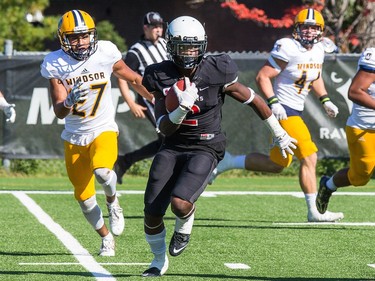 Ravens DB Tunde Adeleke, with Jordan Kelly in pursuit,  runs back a kick off for a touch down as the Carleton Ravens take on the Windsor Lancers in OUA football action at MNP Park on the Carleton University campus.