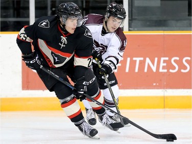 Ravens forward  Alexandre Boivin, left, and Gee Gee player Jacob Harris battle for the puck in the first period.