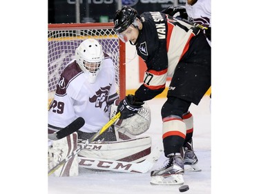 Ravens forward Ryan Van Stralen looks for the loose puck in front of Gee Gee goalie Graham Hunt in the first period.