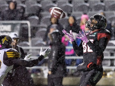 Redblacks receiver Juron Criner, right, catches the ball for a touchdown during the first half despite Derrius Brooks defending.