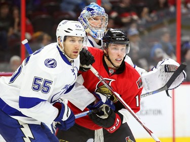 Ryan Dzingel of the Ottawa Senators battles against Braydon Coburn and goalie Andrei Vasilevskiy.