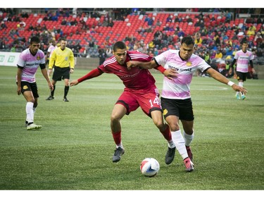 The Ottawa Fury's Onua Obasi (14) battles Fort Lauderdale's Junior Sandoval for the ball.