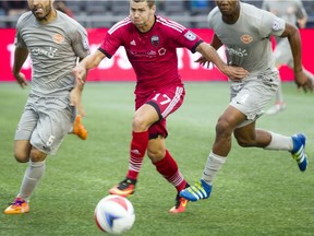 The Ottawa Fury FC's #17 Carl Haworth battles Puerto Rico FC's #5 Ramon Soria and #4 Rudy Dawson for the ball at TD Place Sunday October 2, 2016.